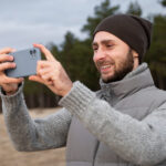 un ragazzo scatta una foto con uno smartphone